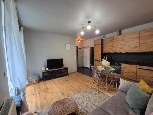 a living room with a couch and a table at Apartament w Willii Szmaragd in Borne Sulinowo