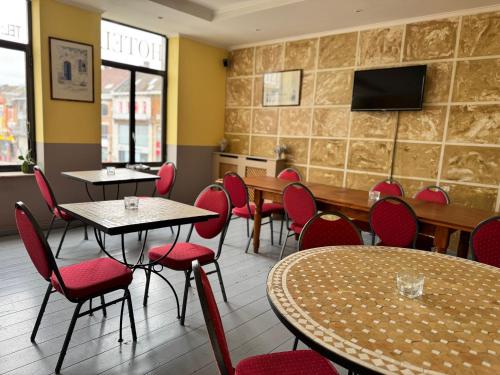 a restaurant with tables and chairs and a tv on the wall at Family Hôtel in Wavre