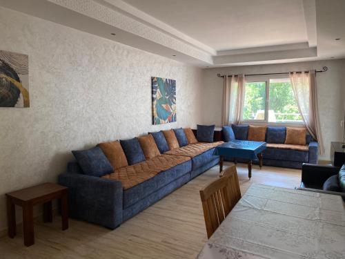 a living room with a blue couch and a table at PLAYA DEL PACHA MARINA SMIR in Fnidek