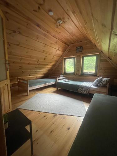 a large room with a bed in a log cabin at Wilkaski zakątek in Giżycko