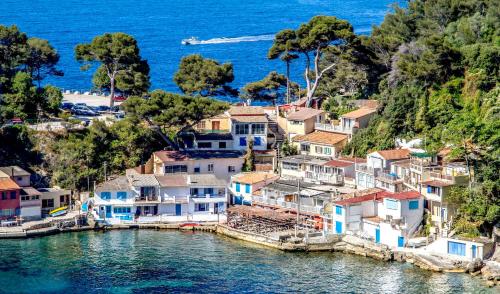 un groupe de maisons sur une colline à côté de l'eau dans l'établissement Spacieux appartement au calme proche de la mer, à Toulon