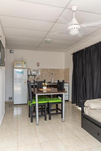 a dining room with a table and chairs and a kitchen at Complejo Lapachos De Colon in Colón
