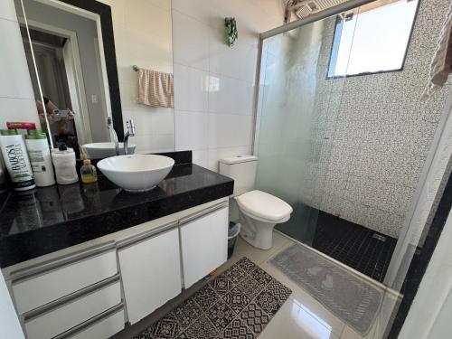 a bathroom with a sink and a toilet and a shower at Apartamento super central até 9 pessoas in Divinópolis