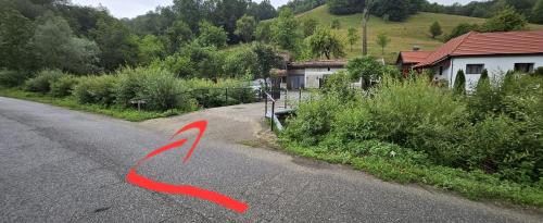 a road with a red arrow pointing to a house at LaShura in Buceş