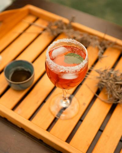 a drink in a wine glass sitting on a wooden table at The Aurelia in Gampola