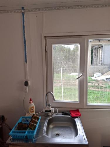 a sink in a kitchen with a window at Tiszavirág Nagyhalas Horgász apartman in Tiszaújváros
