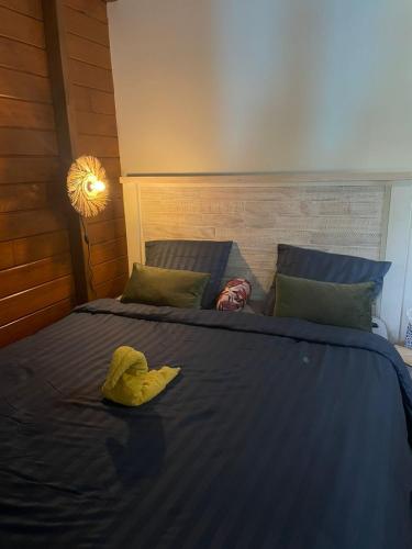 a bed with a blue comforter and a yellow blanket at Bienvenue au cocon de Moreau in Goyave