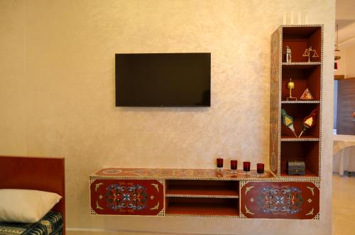 a living room with a television on a wall at Appartement Nadine Fès in Fès