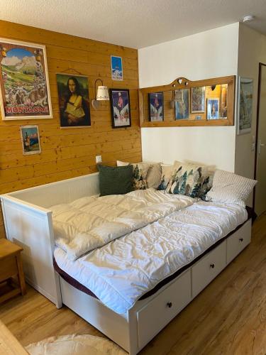 a large bed in a room with wooden walls at Studio Alpin & Bien-Être in Brides-les-Bains