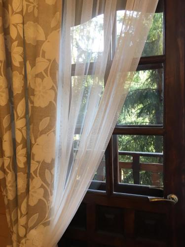 a window with a white curtain in front of it at Burger Trostyan Guest House in Slavske