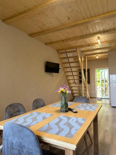 a dining room table with chairs and a vase of flowers on it at Vista Krasiya in Vyshka