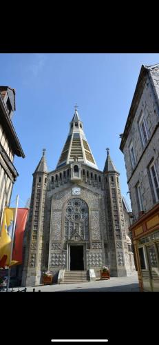 a large building with a tower on top of it at La LOGE entre Pierre & Histoire in Domfront