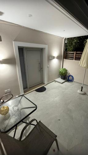 a living room with a glass table and a patio at Filippos House in Preveza