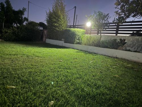 a grassy yard with a fence and a light at Filippos House in Preveza