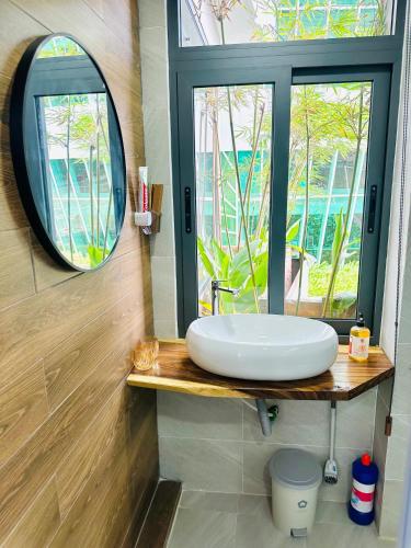 a bathroom with a white sink and a mirror at 202MSNK Luxe Studio w Balcony & Kitchen in Can Tho