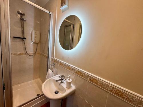 a bathroom with a sink and a mirror and a shower at Seagulls Rest - Sheringham in Sheringham