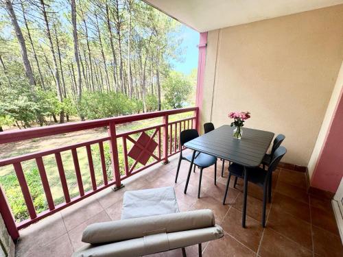 balcone con tavolo e sedie. di T2 Lacanau - Cosy au calme sur le golf & Océan a Lacanau