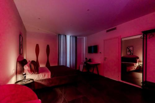 a pink room with a bed and a mirror at Marenda - B&B in Bari