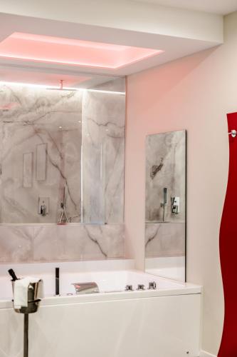 a bathroom with a tub and two mirrors at Marenda - B&B in Bari