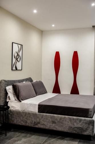 a bedroom with a bed with two vases on the wall at Marenda - B&B in Bari