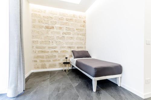 a bed in a room with a brick wall at Marenda - B&B in Bari