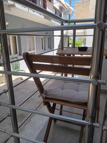 a wooden chair with a cushion sitting on a balcony at Inatos Paradise studio 1 in Tsoútsouros