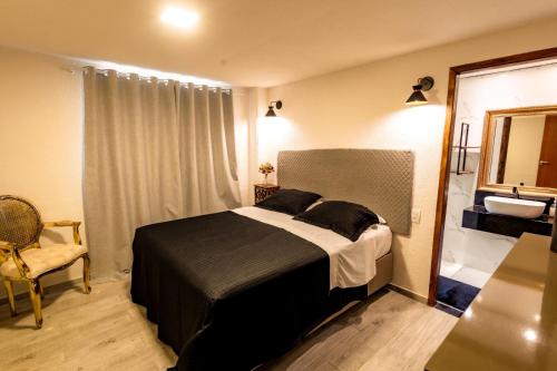 a bedroom with a bed and a mirror and a sink at Apartamento Villa Siena Condomínio À Beira Mar próximo ao Aeroporto in Salvador