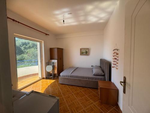 a bedroom with a bed and a tv and a window at Harbour View Stay in Himare