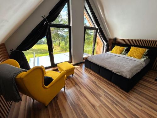 a bedroom with a bed and a large window at Mazurskie Wzgórze Nad Jeziorem Isąg in Pelnik