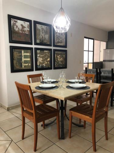 a dining room with a table with chairs and a chandelier at MAI Cozy Apartment 2BR AC and Parking Quiet Stay in Puerto Vallarta