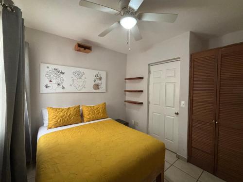a bedroom with a yellow bed and a ceiling fan at MAI Cozy Apartment 2BR AC and Parking Quiet Stay in Puerto Vallarta