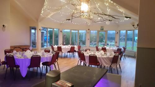 a banquet hall with tables and chairs and a chandelier at Callander Hostel in Callander