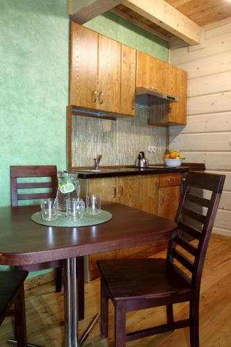 a kitchen with a wooden table with glasses on it at Domek pod Howyzem in Łapsze Niżne