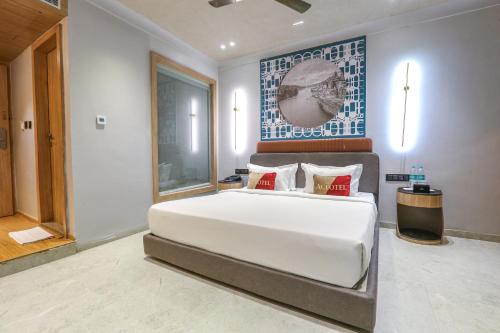 a bedroom with a large white bed with red pillows at Aceotel Select Aria, Bhopal -A Luxury Boutique Hotel in Bhopal