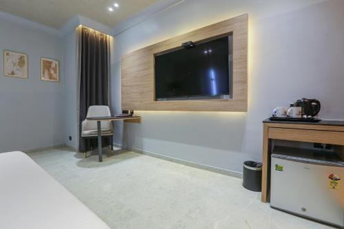 a hotel room with a flat screen tv on the wall at Aceotel Select Aria, Bhopal -A Luxury Boutique Hotel in Bhopal