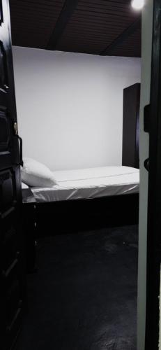 ボゴタにあるHotel Migraciónの白いマットレスが備わる客室の小さなベッド1台分です。