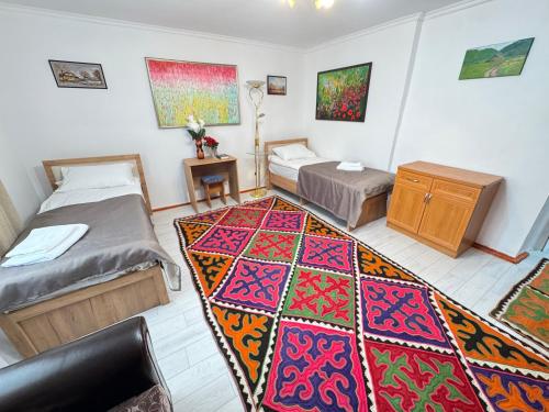 Habitación con 2 camas y alfombra en el suelo en Guest hause in Naryn, en Tashbulak