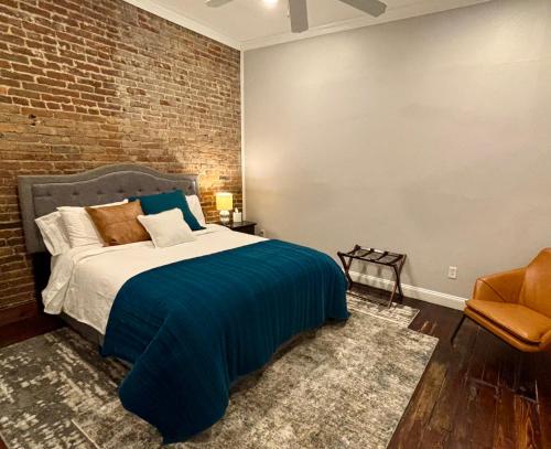 a bedroom with a bed and a brick wall at In the Heart of Town-3BR-2bath-500Mbps WiFi-4car parking-EV-boat in Florence