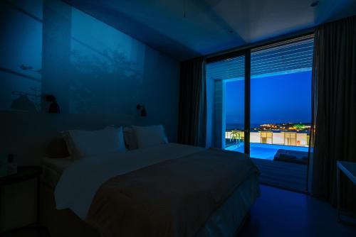 a bedroom with a bed and a window with a view at Zante Maris Suites - Adults Only in Tsilivi