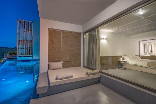 a bedroom with a bed and a swimming pool at Zante Maris Suites - Adults Only in Tsilivi