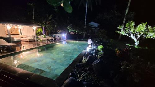 a swimming pool in a backyard at night at Ecolodge Mata Api Bungalow Ylang-Ylang in Mataiea