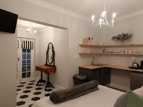 a room with a bed and a sink and a mirror at Bij De Graaff in Graaff-Reinet