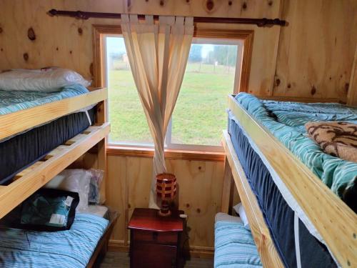 a room with two bunk beds and a window at Cabañas Los Tatas in Puerto Octay