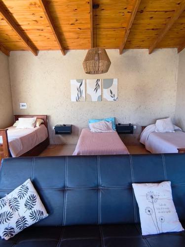 a living room with two beds and a couch at Complejo de cabañas Vida Paz in Las Calles