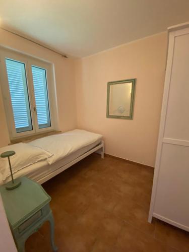 a small room with a bed and a mirror at Villa Incanto in Ascona