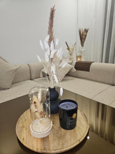 a coffee table with a glass jar and a vase at Appartement luxueux et cosy Marina Saïdia in Saidia 