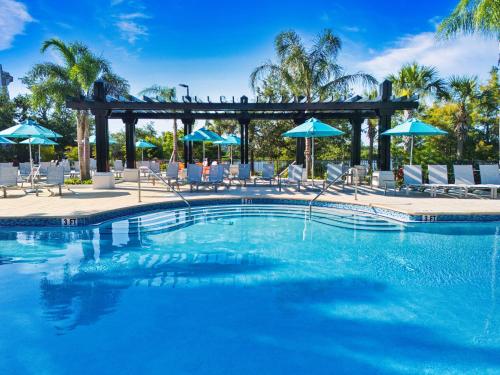 a large swimming pool with chairs and umbrellas at VistaCay Balcony near Pool Convention Ctr iDrive in Orlando