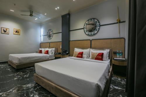 a bedroom with two beds and a clock on the wall at Aceotel Select Aria, Bhopal -A Luxury Boutique Hotel in Bhopal
