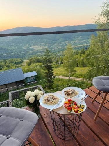 two plates of food sitting on a table on a deck at Vista Krasiya in Vyshka