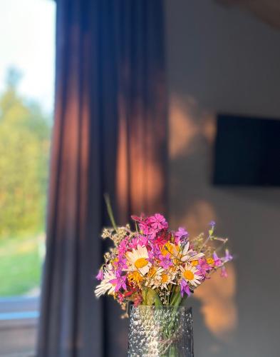 a vase filled with flowers sitting on a table at Vista Krasiya in Vyshka
